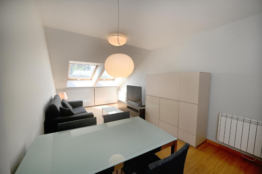 a living room with a white table and a couch at BICOS ao MAR in Rianjo