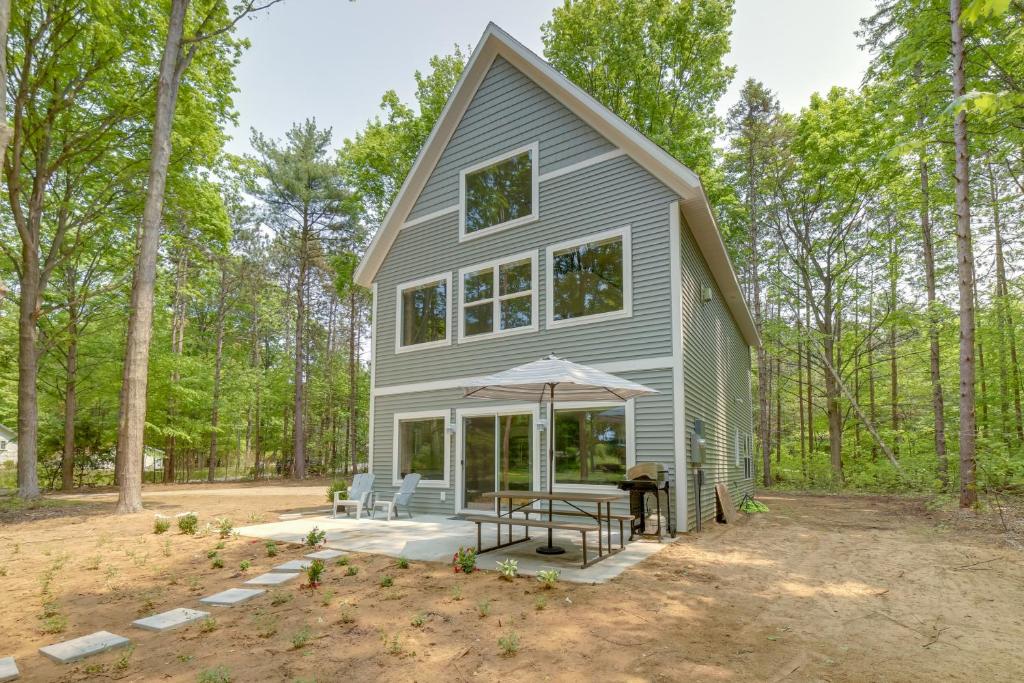 a house in the woods with a picnic table at Holland Home with Fire Pit Walk to Lake Michigan! in Holland