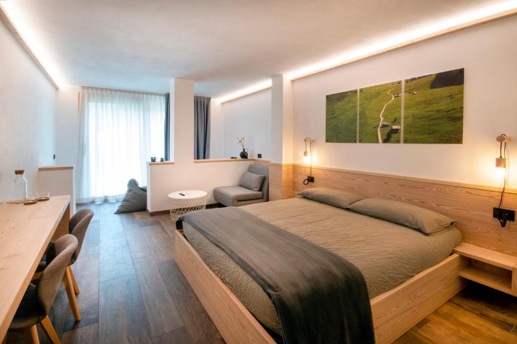 a hotel room with a bed and a desk and a table at BORMIO N'JOY in Bormio