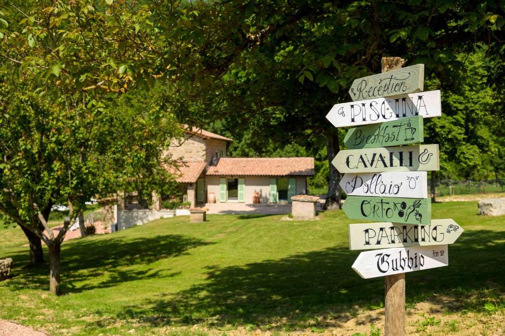 a street sign with arrows pointing in different directions at Lo Smarrino agriturismo in Gubbio
