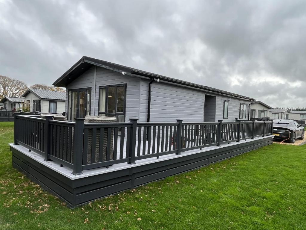 a house with a large deck on a yard at Luxurious 2-Bed Lodge in St Helens Ryde in Saint Helens