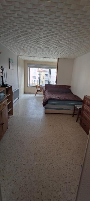 une chambre avec un lit et une grande fenêtre dans l'établissement Studio et parking privé bord de mers, au Cap d'Agde