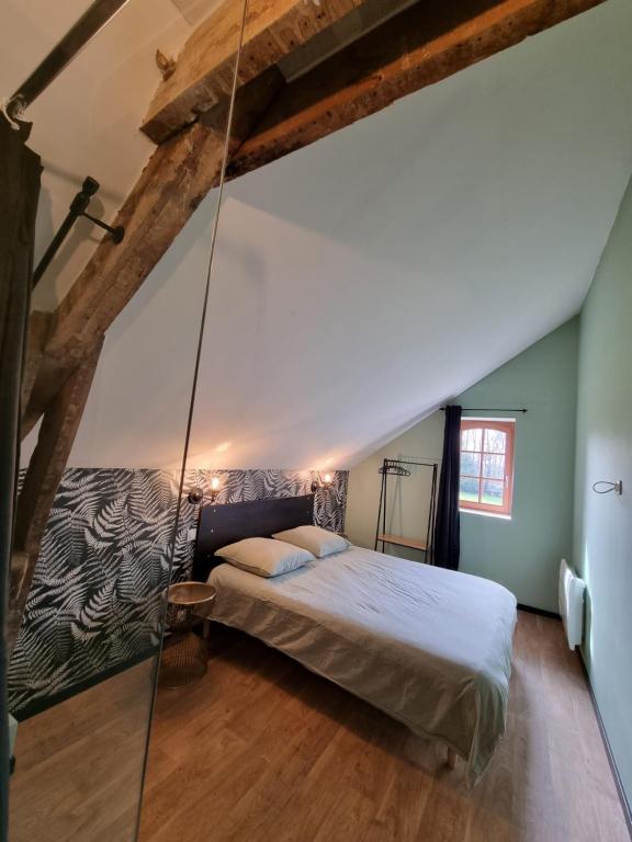 a bedroom with a swinging bed in the attic at Les Ecuries du Château de Brumare in Brestot