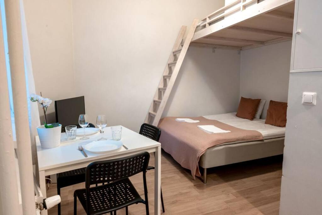 a small room with a bed and a table and a bunk bed at 2ndhomes Kamppi Apartments 3 in Helsinki