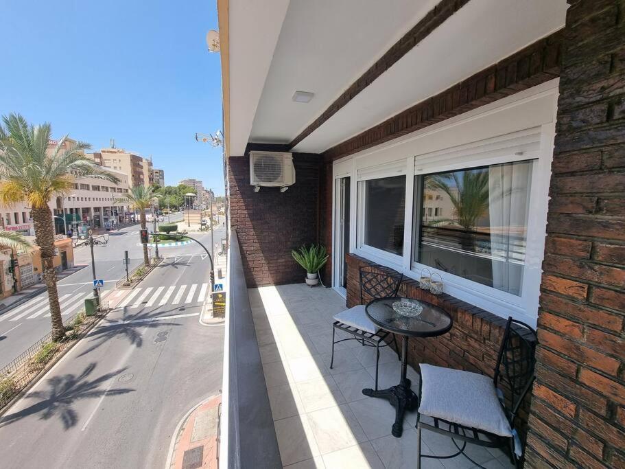 a balcony of a building with a table and a window at Santa Monica Suites, 2 hab con terraza, parking y playa a 5 min a pie in Aguadulce