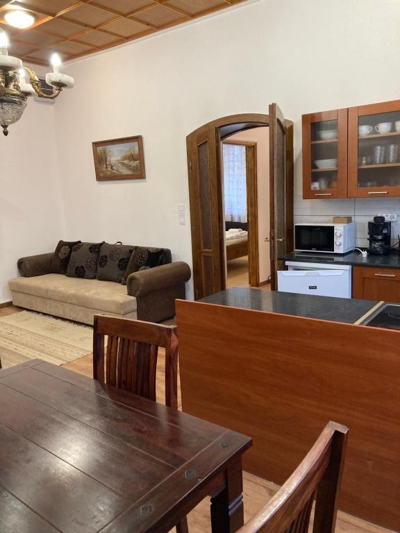 a kitchen and living room with a couch and a table at Cédrus apartman in Pécel