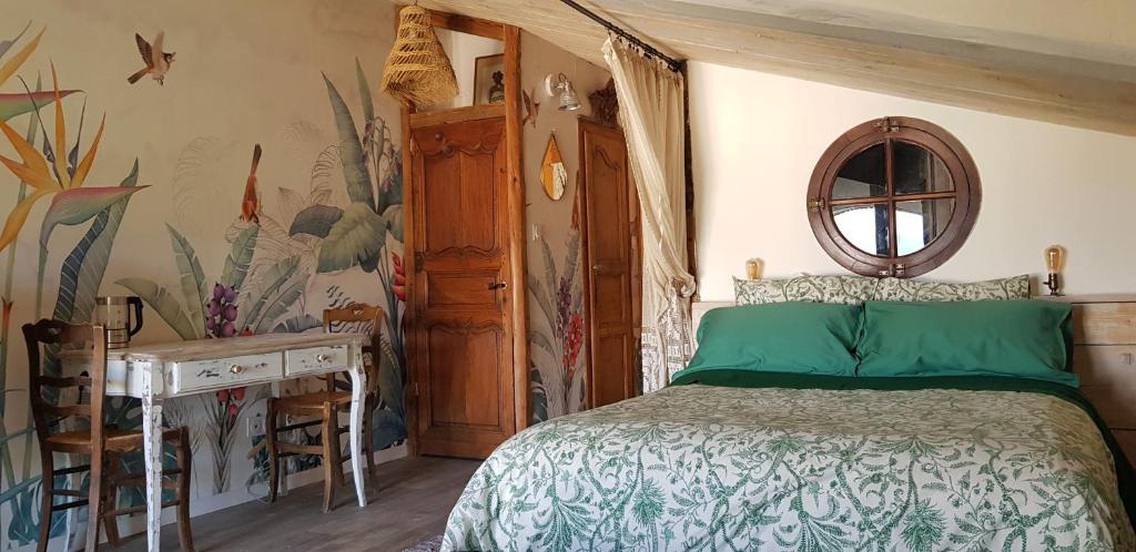 a bedroom with a bed and a desk in a room at La Bohême in Charols
