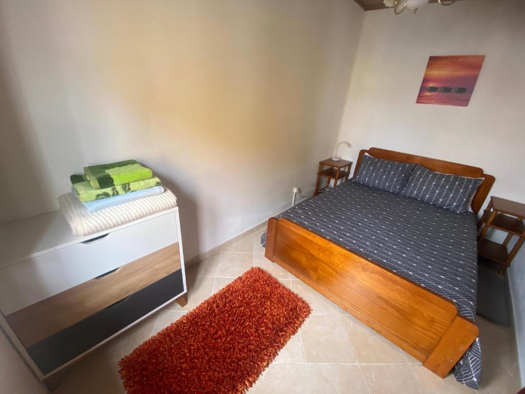 a bedroom with a bed and a table with a rug at Cantinho da Avó in Vila do Bispo