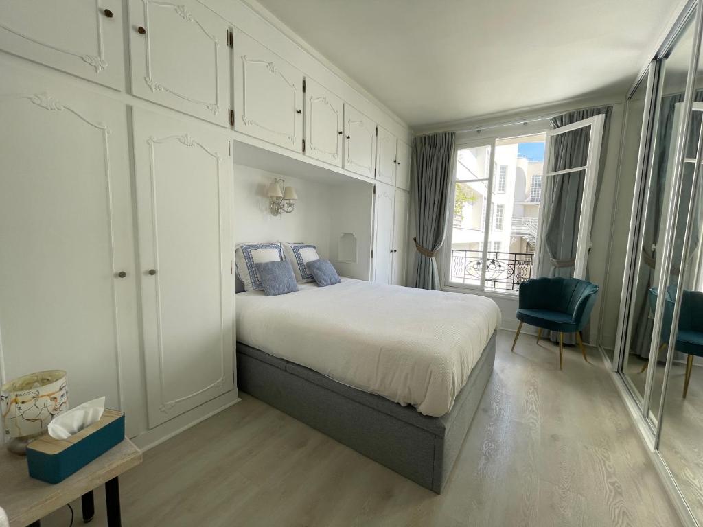 a bedroom with a large bed with blue pillows at Appartement 2 pièces élégant proche Porte de Versailles in Paris