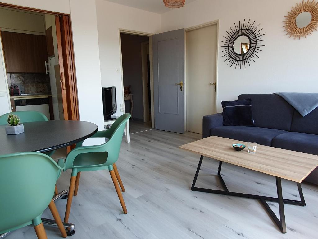 a living room with a couch and a table and chairs at GRENIER DES CIGOGNES in Sélestat