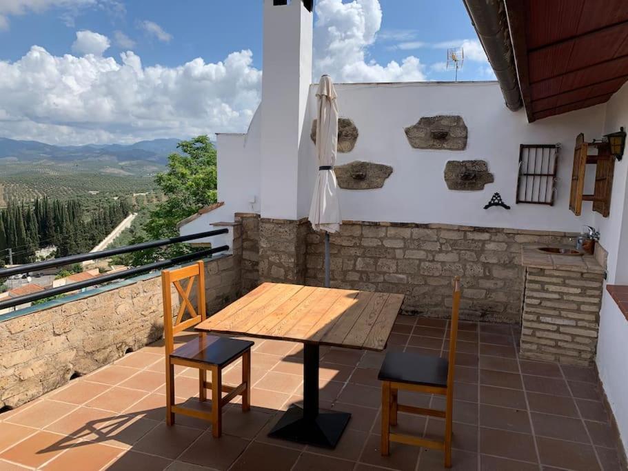 einen Holztisch und zwei Stühle auf dem Balkon in der Unterkunft Casa Rural El Gran Encanto in Cazorla