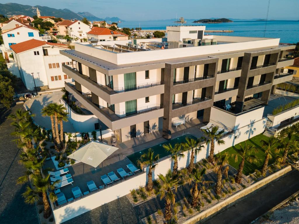 an aerial view of a building with palm trees and the ocean at Hotel Crystal in Orebić
