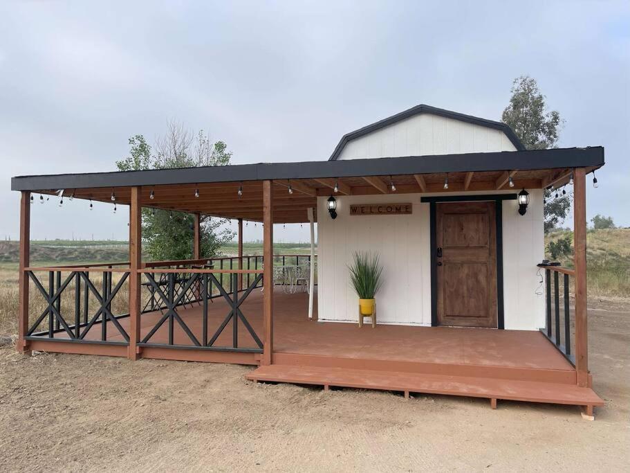 un bâtiment avec une terrasse couverte et une porte. dans l'établissement Modern wine country barn house, à Temecula