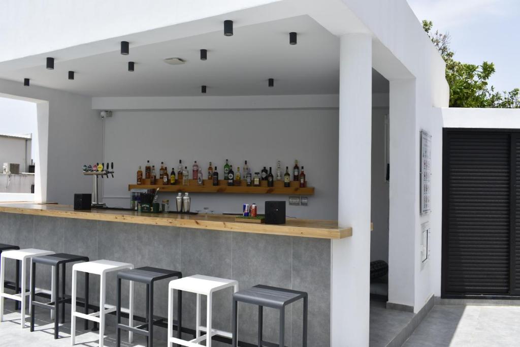 a bar with stools in front of a building at Zoi Ayia Napa in Ayia Napa