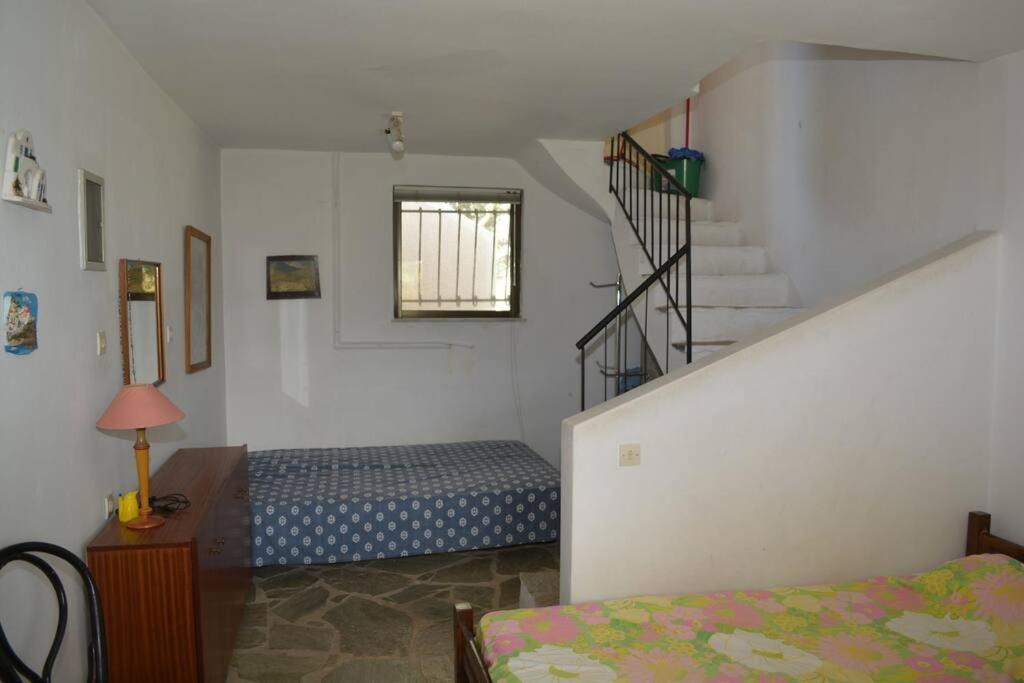 a bedroom with a bed and a stair case at Παραθαλάσσια μεζονέτα! in Kamena Vourla