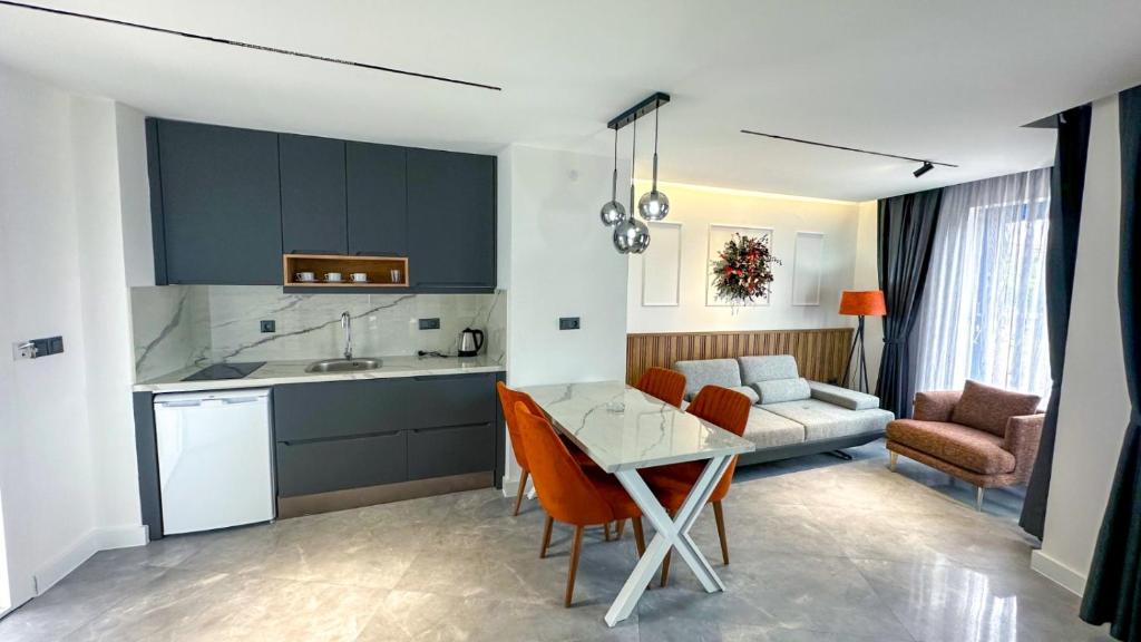 a kitchen and living room with a table and chairs at Happy Apart Hotel in Kuşadası