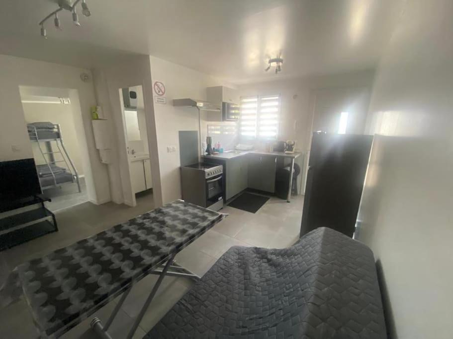 un salon avec une table et une cuisine dans l'établissement Cosy T2 près aéroport CDG Disney, à Claye-Souilly