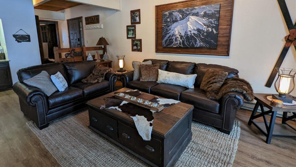 uma sala de estar com um sofá de couro e uma mesa de centro em Lone Mountain Retreat em Big Sky