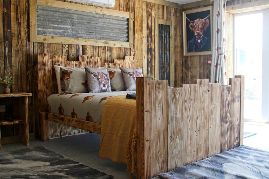 um quarto com uma cama e uma parede de madeira em The Moo-tel at Bargoed Farm em Aberaeron