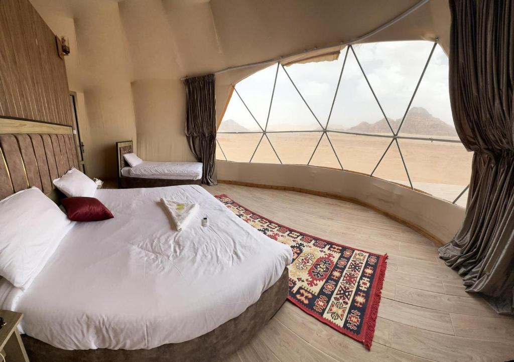 a room with two beds and a large window at RUM iSLAND LUXURY CAMP in Wadi Rum