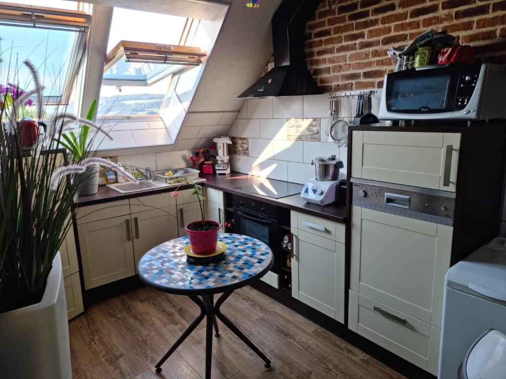 a small kitchen with a table with a cup on it at Appartement atypique climatisé in Semur-en-Auxois