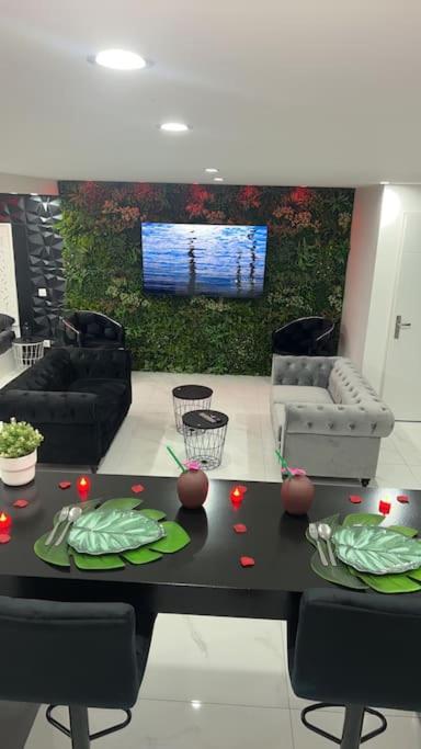 a living room with a table and chairs and a television at Love room borabora in Reyrieux