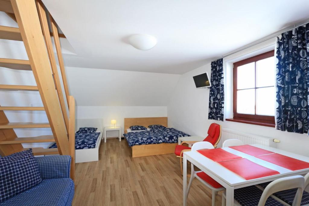 ein kleines Zimmer mit einem Bett, einem Tisch und einem Sofa in der Unterkunft Apartmány Fox in Boží Dar
