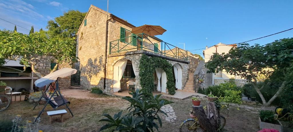 a building with a balcony on the side of it at Stone House with garden Laganini in Zlarin
