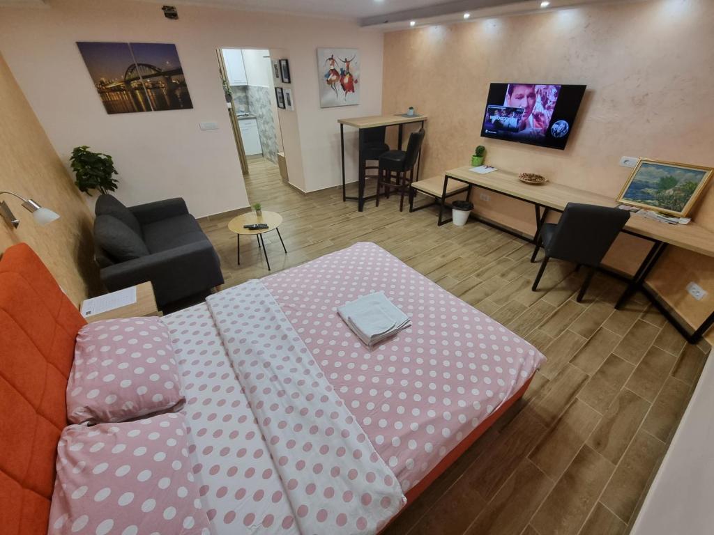 a living room with a couch and a table with a desk at Apartman DoDoLuLu in Belgrade