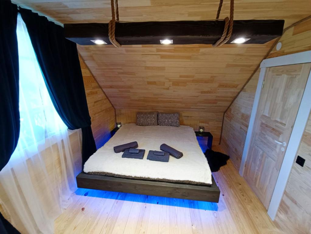 グルベネにあるProvinces Idilleの木製の壁の小さな部屋のベッド1台分です。