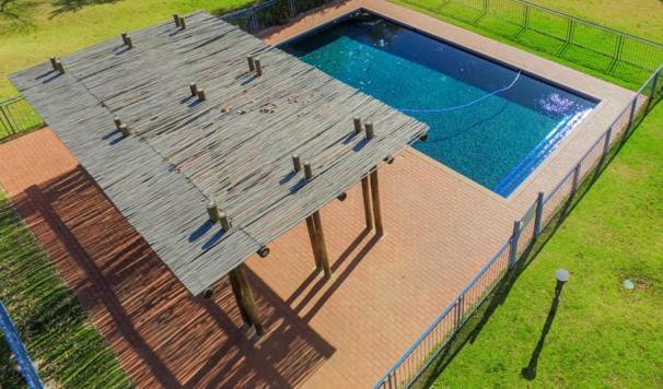 uma grande piscina com telhado de madeira em Jackal Creek em Joanesburgo