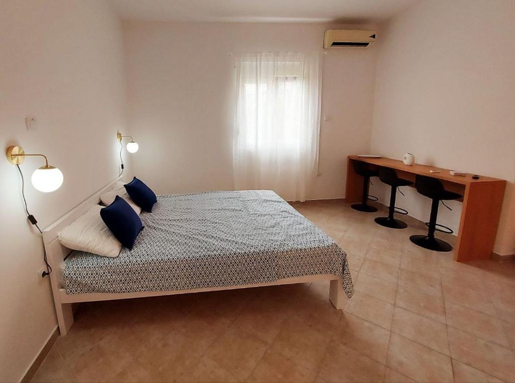 a bedroom with a bed and a desk in it at Apartmani Radovic in Bijela