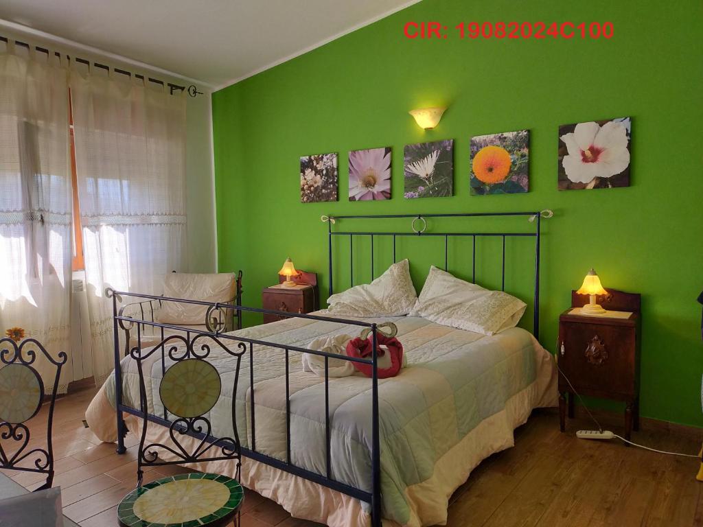 a bedroom with a green wall with a bed and two lamps at Casa Vacanze TwentyMiles in Castellana Sicula