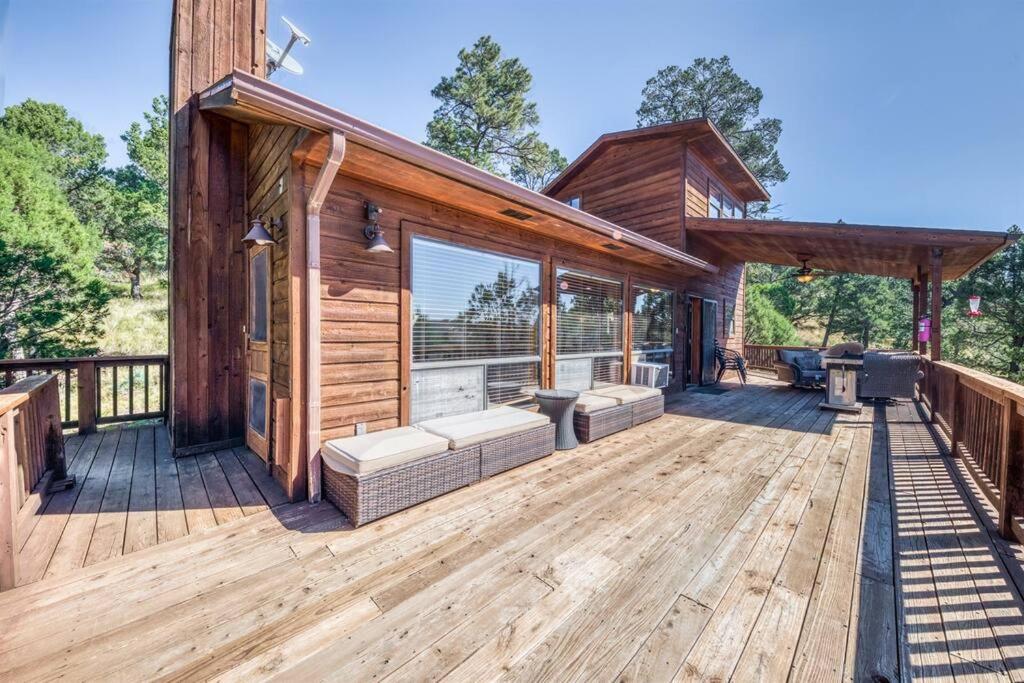 a log cabin with a large wooden deck at Perk Canyon Hidden Acres-Hot Tub-Gas Fireplace in Ruidoso