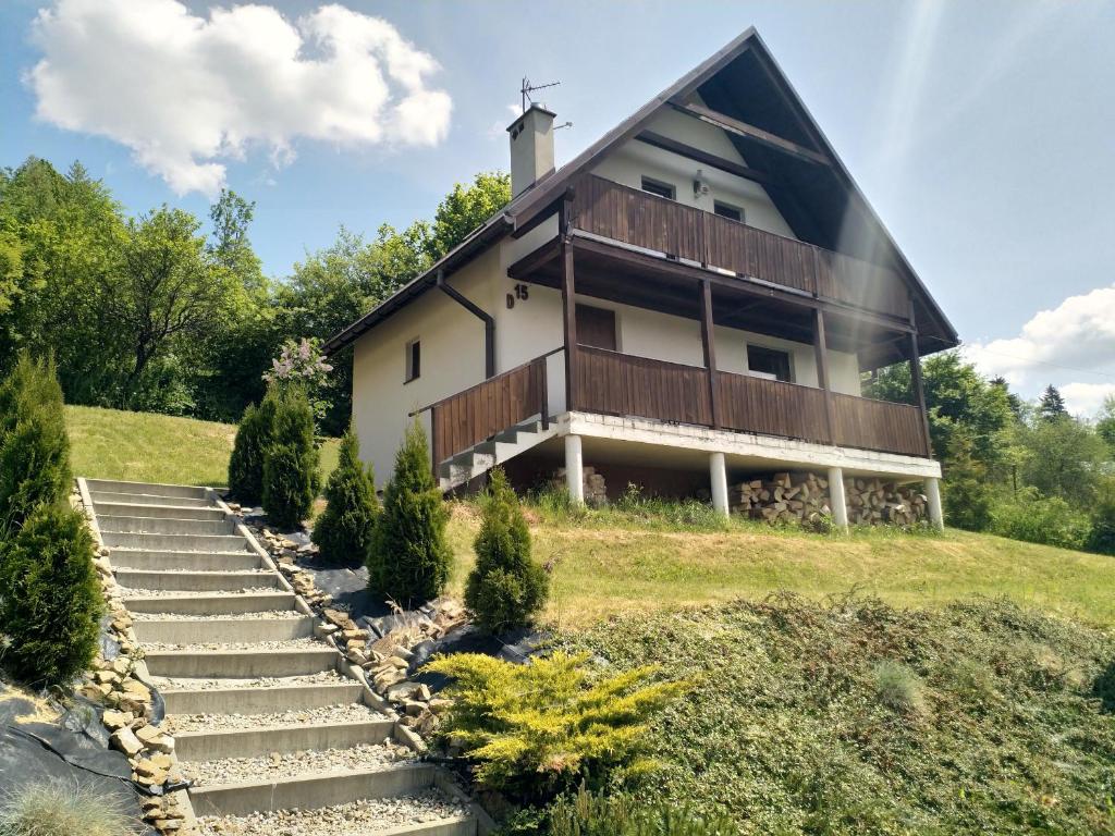 ein Haus auf einem Hügel mit Treppe davor in der Unterkunft Domki Nad Strumykiem in Krościenko nad Dunajcem