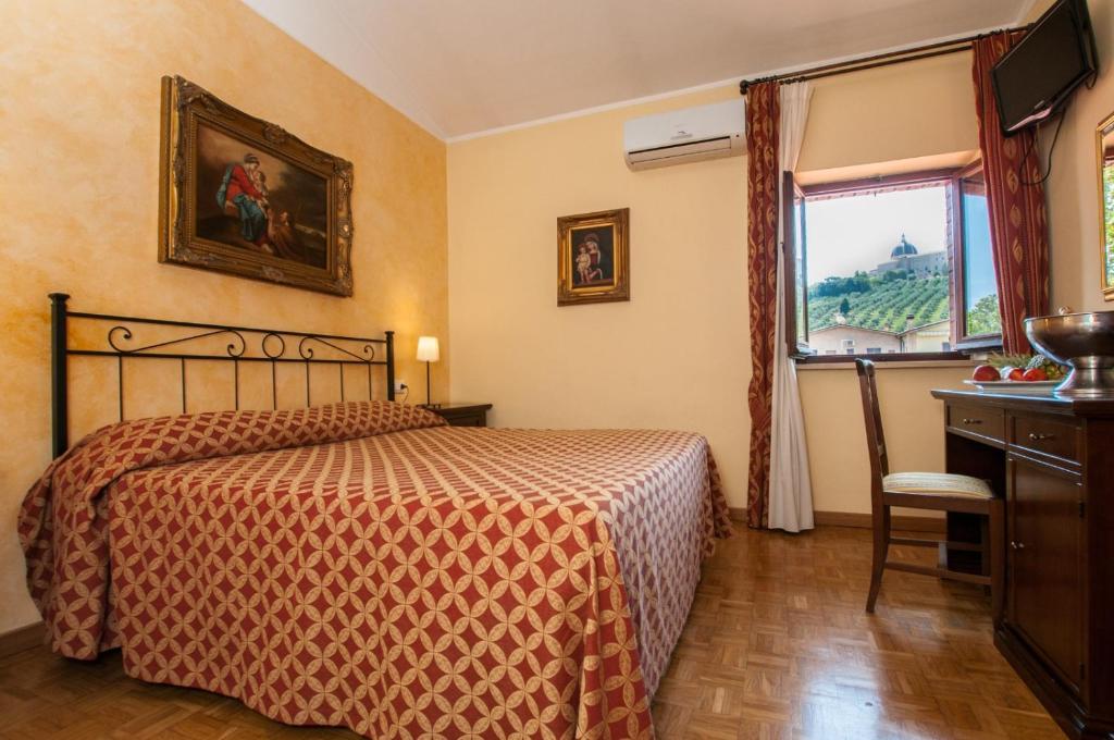 um quarto de hotel com uma cama e uma janela em Vecchia Fattoria em Loreto