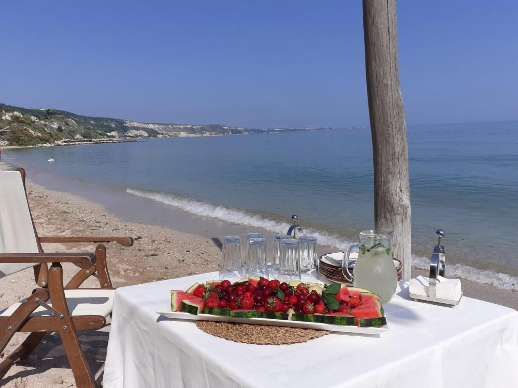 uma mesa com um prato de frutas na praia em Thracian cliffs Апартамент Голф холидей em Kavarna