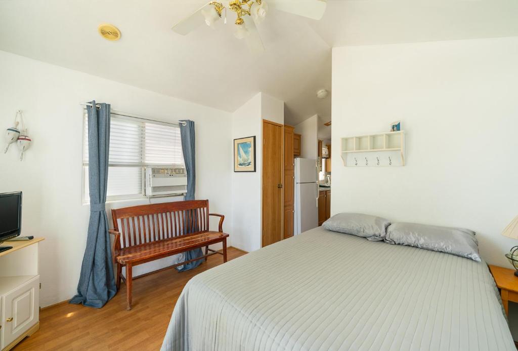 una camera con letto, sedia e televisore di Snug Harbor RV Park & Marina a Walnut Grove
