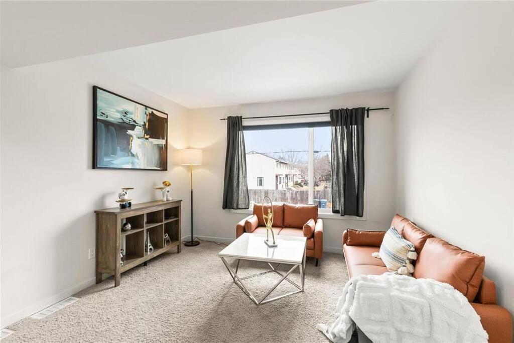a living room with a couch and a table at Quiet, modern, stylish, one King & two Queen size beds, central location, parking in Winnipeg