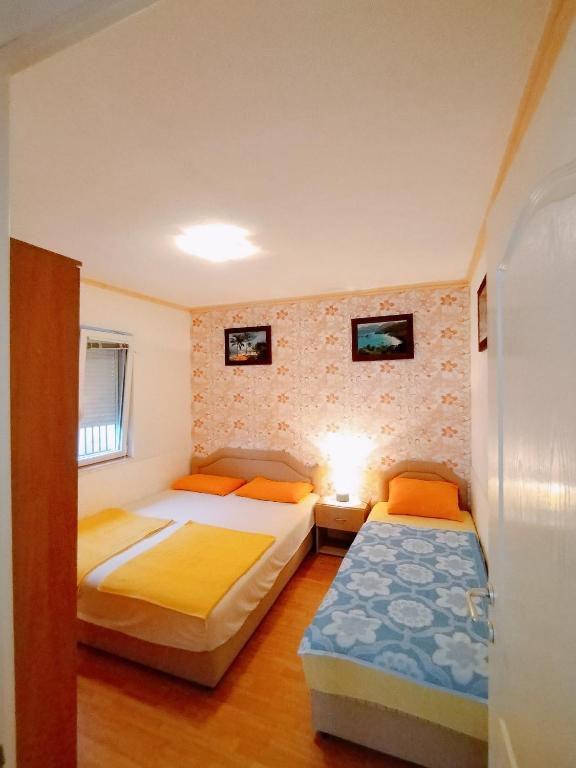 Postel nebo postele na pokoji v ubytování Apartmani LJUBICA