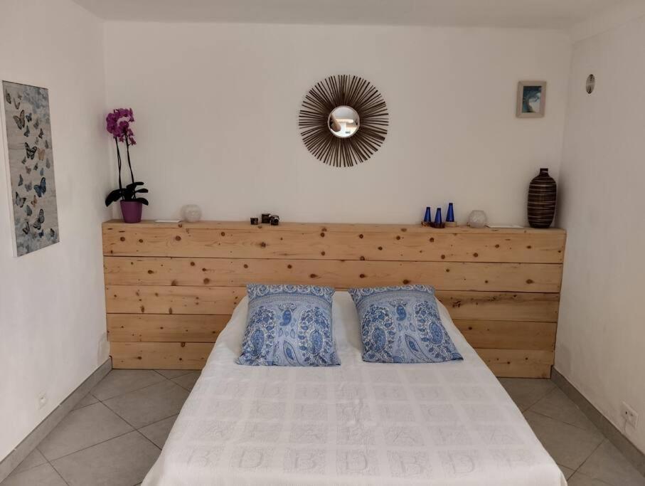 ein Schlafzimmer mit einem Bett mit zwei Kissen und einem Spiegel in der Unterkunft Studio avec jacuzzi privatif. in Grasse