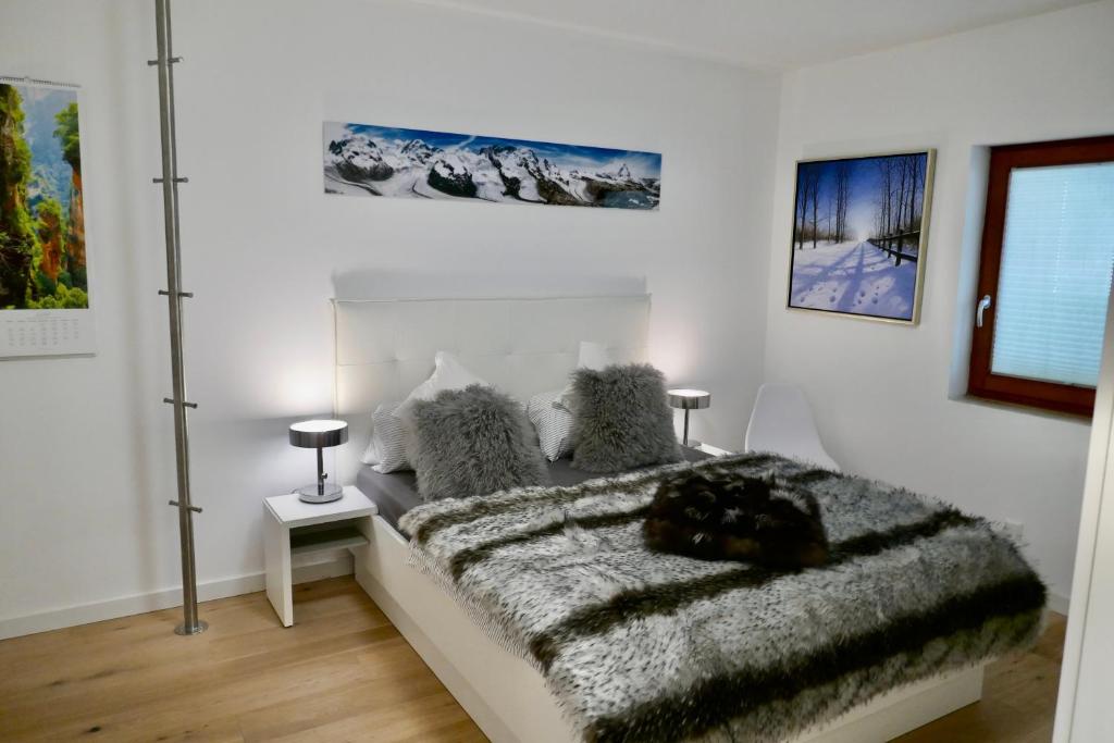 biała sypialnia z łóżkiem z futrzanym kocem w obiekcie 42up Berlin Pankow w Berlinie