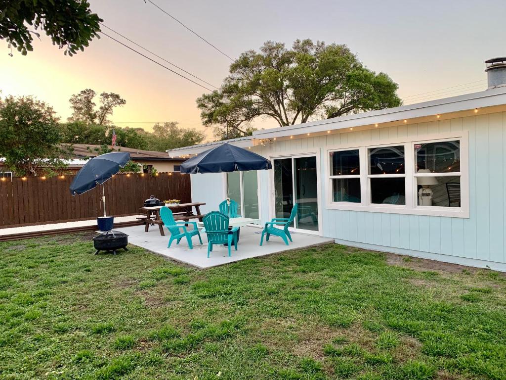 un patio con sillas, mesas y sombrillas en Seashell House, en Clearwater