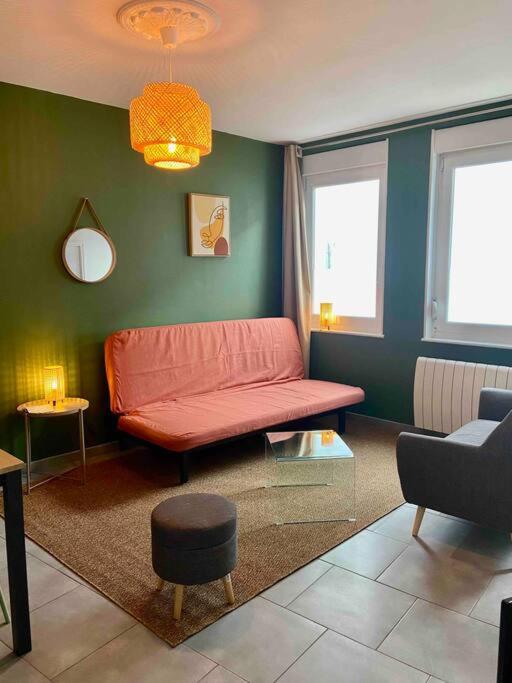 un salon avec un canapé rouge et des murs verts dans l'établissement Maison de pêcheur-Étaples (proche Touquet), à Étaples