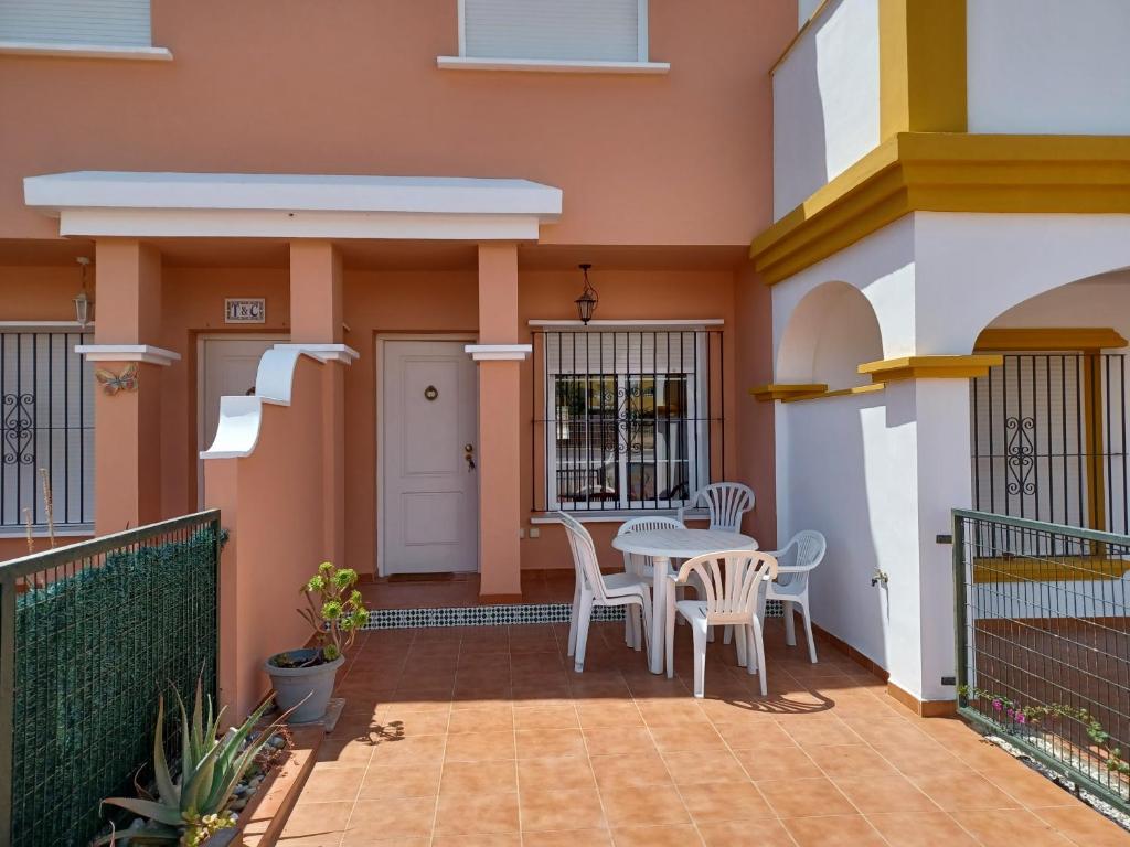 una casa con patio con mesa y sillas en AS019 2-Bedroom Casa Calypso - in Calas del Pinar, en San Juan de los Terreros