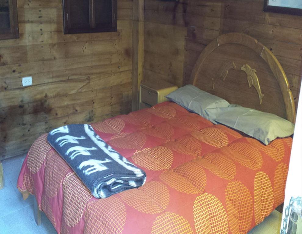 a bedroom with a bed in a wooden cabin at La Casa Suiza in Huanchaco