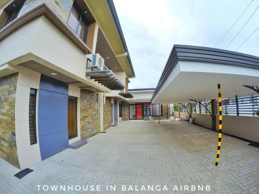 a house with a balcony and a building at Stylish Townhouse in Balanga City Quiet Neighborhood in Balanga