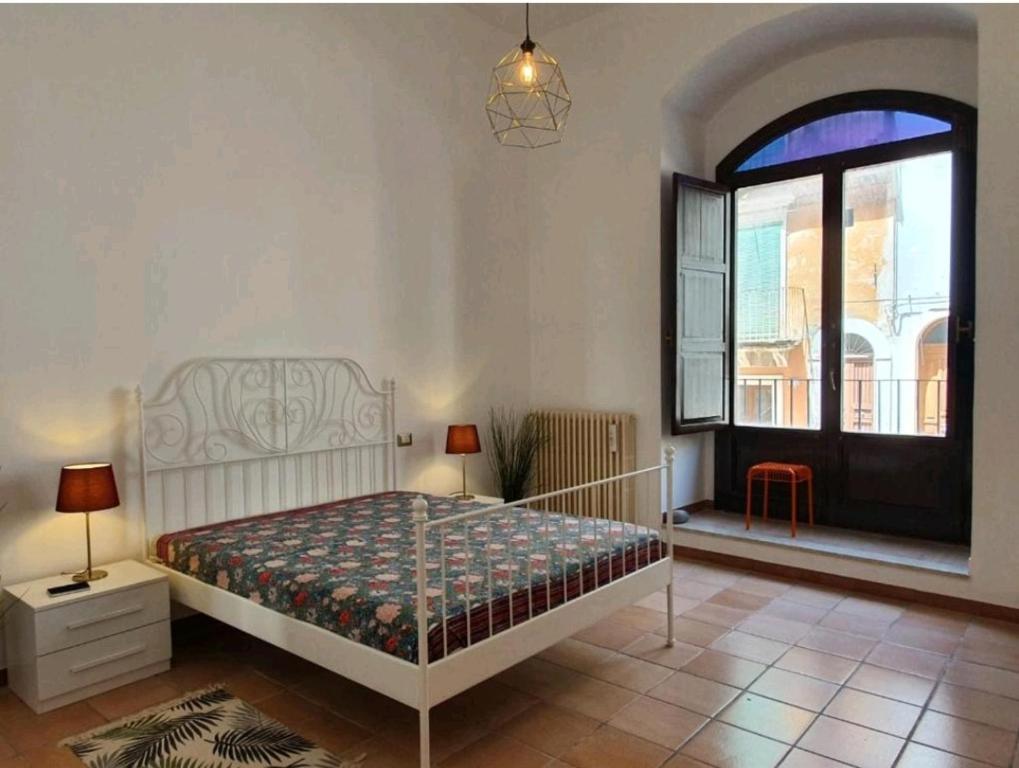 1 dormitorio con cama y ventana grande en Stanza privata nel cuore del barocco ragusano, en Ragusa