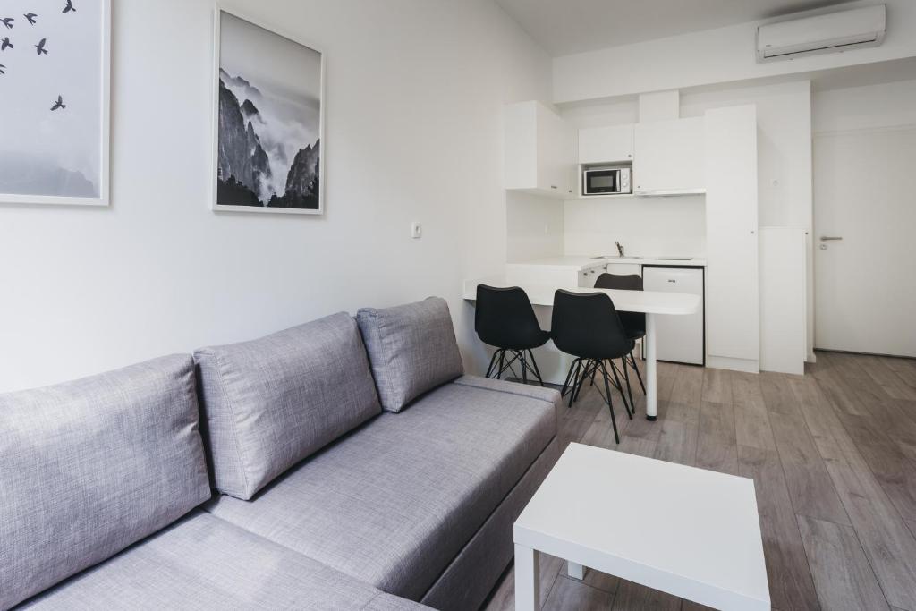 ein Wohnzimmer mit einem Sofa und einem Tisch in der Unterkunft Mika Apartment and Studios in Zagreb