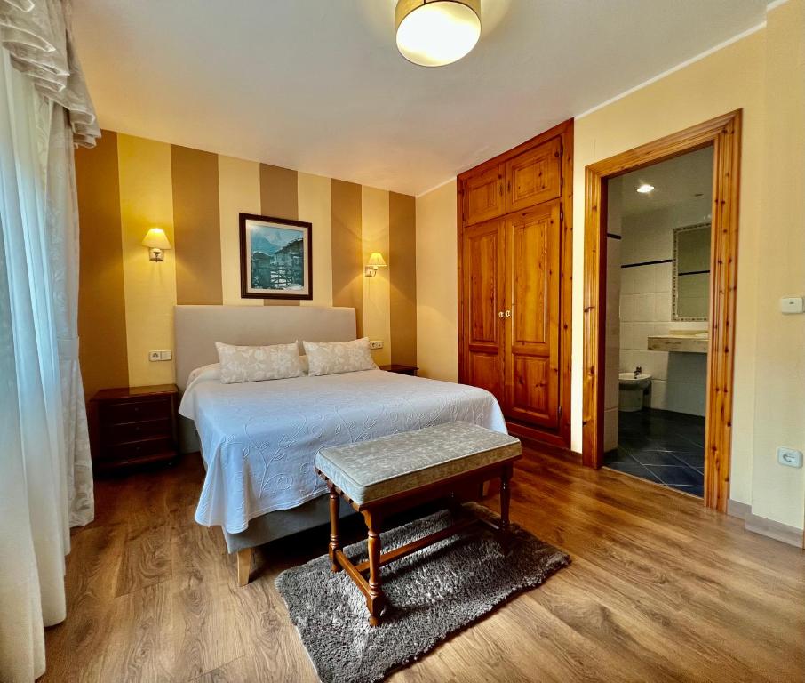 a bedroom with a bed and a table in it at Hotel La Rivera in Arenas de Cabrales